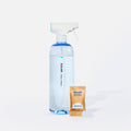 A clear spray bottle filled with blue liquid is labeled Blueland Clean and sits next to a brown packet labeled Blueland Cleaner Tablet Unscented and a white cleaning tablet, all on a white background.