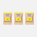 Three brown packets of the Toilet Bowl Cleaner Sample Pack (3 Tablets) in Lemon Cedar scent stand upright, showcasing one round white tablet. The packaging features a yellow circle and is simple and plastic-free, emphasizing the products eco-friendly design.